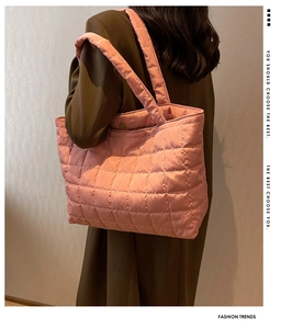 Pink quilted tote bag detail showing puffy polyester texture and shoulder strap on model