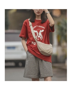 Outdoor street style view of beige nylon crossbody dumpling bag with a casual summer outfit