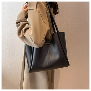 Detail of black leather tote bag with fine grain texture and vertical stitching detail