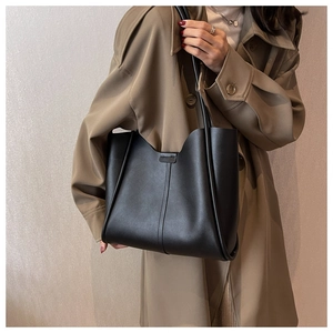 Close-up of minimalist black matte leather tote bag with vertical stitching detail