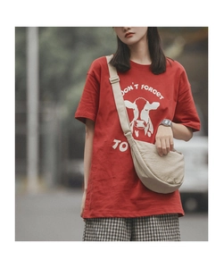 Close-up of a cream nylon crescent crossbody bag styled with a red printed casual t-shirt