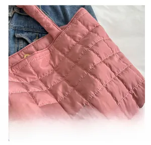 Detail shot of the pink quilted tote bag showing high-quality stitching and metal button