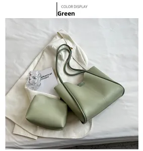 Detailed set of sage green PU leather tote bag and inner pouch on white bedding