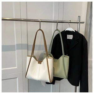 Detailed view of large tote bags in white and bean green showing soft leather texture