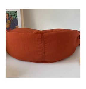 Close-up of orange nylon crossbody bag showing detailed stitching and fabric texture