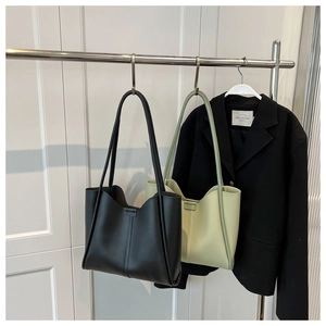 Detail of minimalist tote bags in black and light green with reinforced stitching on sides