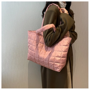 Close-up of pink quilted puffer tote bag with soft padded handle and spacious design