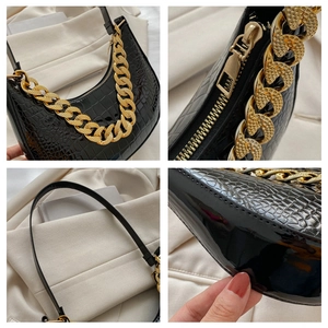 Detailansicht der schwarzen Kroko-Hobo-Tasche mit grober Goldkette und Metall-Reißverschluss