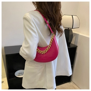 Nahaufnahme der pinken Hobo-Tasche mit Krokoprägung und klobiger goldener Kette
