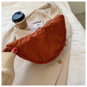 Detail of red-brown nylon crescent bag with durable double stitching and casual urban style
