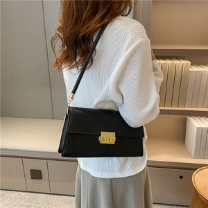 Chic black crocodile pattern square shoulder bag with gold metal buckle on model