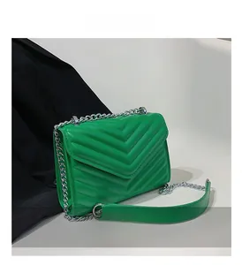 Close-up of bright green quilted leather bag with V-shaped texture and silver chain strap