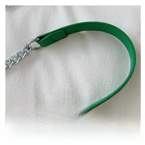 Detail of bright green leather shoulder strap with silver metal chain and stitching