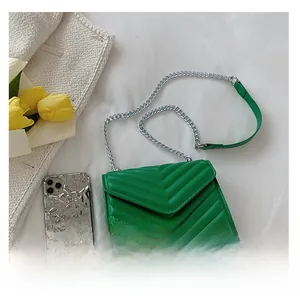 Close-up of green quilted bag with V-shaped stitching and silver chain shoulder strap