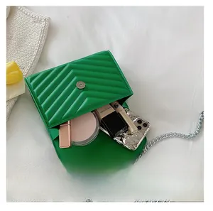 Internal capacity of green quilted crossbody bag showing phone and cosmetics
