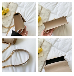 Detailweergave van beige schoudertas met focus op bodemstructuur en gouden ketting