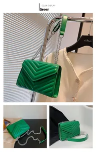 Detailed view of green chevron quilted crossbody bag with silver chain strap and flap closure