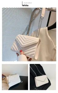 Close-up of white quilted PU leather handbag with V-stitch patterns and silver chain strap