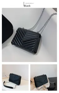 Detailed close-up of a black crossbody bag with V-shaped quilted texture and silver chain