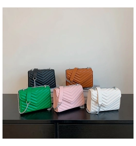 Five quilted small square bags in various colors with metallic chain straps