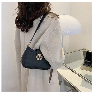 Détail macro d'un sac à bandoulière en cuir noir gaufré avec un fermoir doré chic