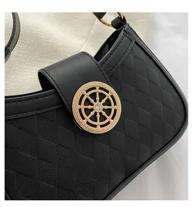 Détail du sac à main matelassé noir avec boucle gouvernail dorée et cristal brillant