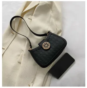 Détail du sac porté épaule à carreaux noirs avec boucle gouvernail dorée et bandoulière