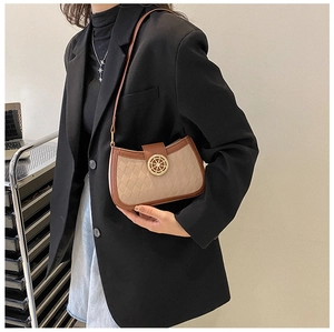 Détail d'un sac sous le bras à carreaux vintage avec un fermoir doré en forme de gouvernail