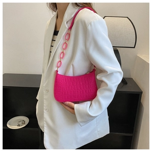 Detail of rose red crocodile pattern shoulder bag with acrylic chain and leather strap