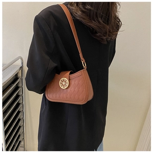 Détail du sac à bandoulière matelassé marron avec décoration dorée en forme de gouvernail