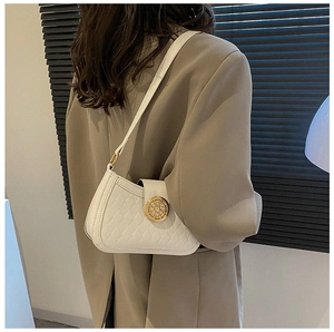 Détail du sac sous le bras matelassé blanc avec boucle en métal doré sur la sangle