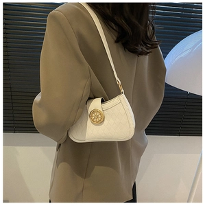 Détail du sac baguette en cuir gaufré blanc avec boucle de roue dorée vintage