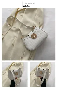 Détail du sac à bandoulière blanc matelassé avec emblème métallique doré élégant