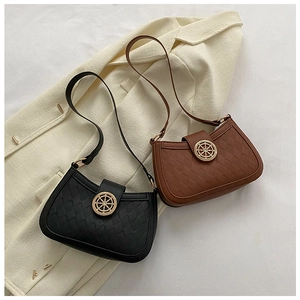 Gros plan de sacs bandoulière en cuir gaufré avec boucle dorée en forme de gouvernail