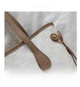 Detailed macro view of white lattice texture and brown leather stitching on tote bag