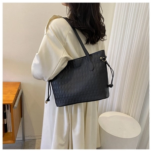 Detail of black quilted tote bag texture and side drawstring on elegant shoulder bag