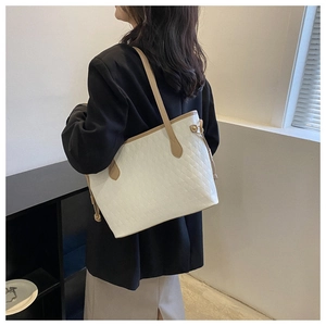 Quilted white leather tote bag shown on model for a stylish casual office look