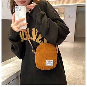 Brown corduroy crossbody bag with Fashion Instinct patch and adjustable shoulder strap