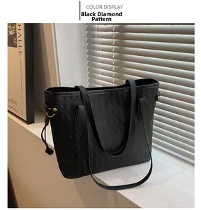 Detail view of black quilted tote bag with diamond pattern on elegant white surface