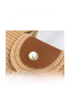 Macro detail of woven bag featuring brown leather flap and large white pearl button closure