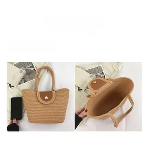 Detail of woven bucket bag featuring brown leather flap closure and pearl button detail