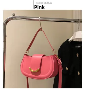Detailansicht einer rosa halbmöndigen Satteltasche mit goldener Metallschnalle und Gurt