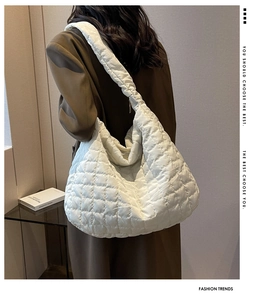 White quilted puffer tote bag shown on shoulder with spacious interior and soft fabric