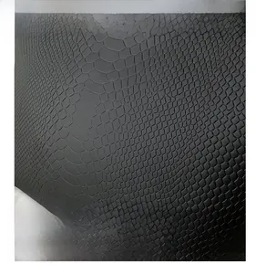 Detailed macro view of black faux crocodile leather texture on tote bag material