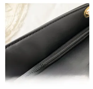 Close-up of a smooth metal zipper and premium stitching on a black leather shoulder bag