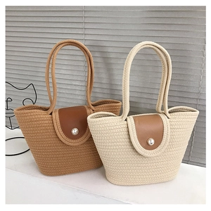 Close-up of woven tote bags featuring brown leather flaps and large pearl button closures