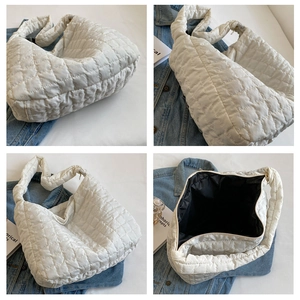 Detail view of white quilted puffer tote bag showing stitching and spacious interior