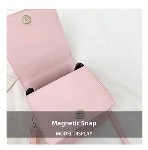 Detailed view of the magnetic snap button closure on a pink mini square crossbody bag