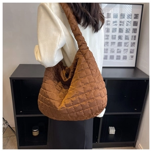 Detail of a brown quilted space cotton tote bag with puffy diamond stitching