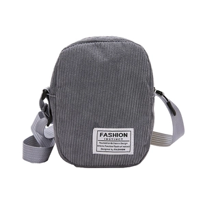 Minimalist grey corduroy crossbody bag with adjustable strap and decorative patch